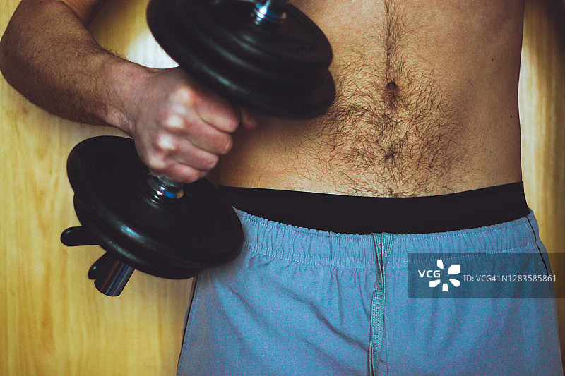 赤膊男人用哑铃锻炼图片素材