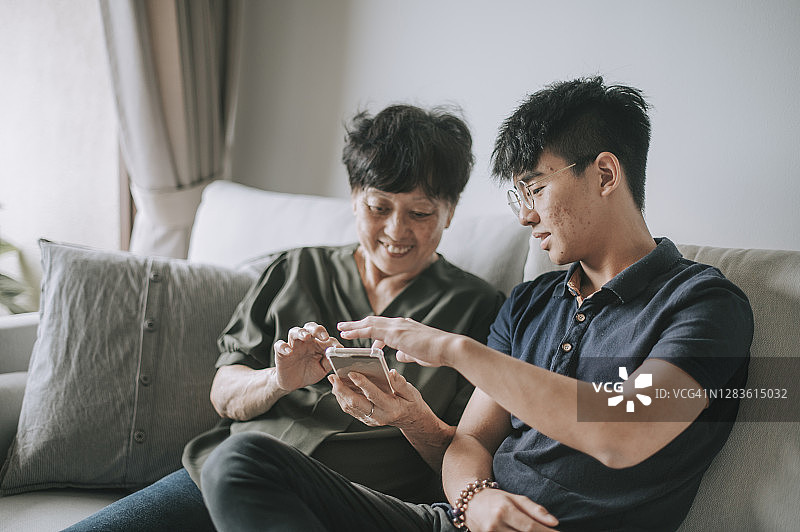 亚洲华人妇女看她的手机检查信息社交媒体上网冲浪图片素材