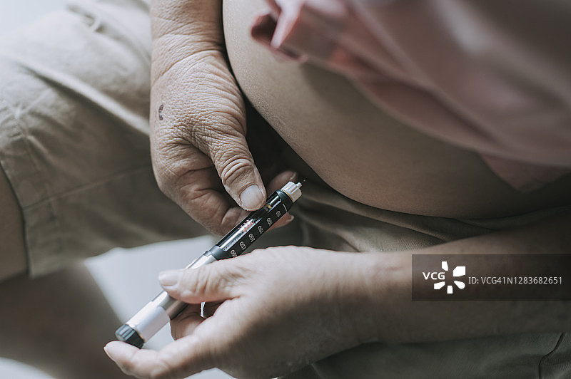 亚洲老年男人日常腹部注射胰岛素图片素材
