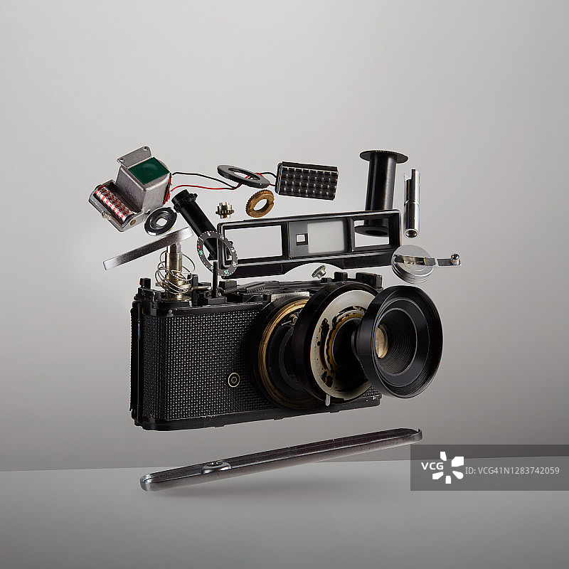 悬浮在空中的老式模拟胶片相机零件图片素材