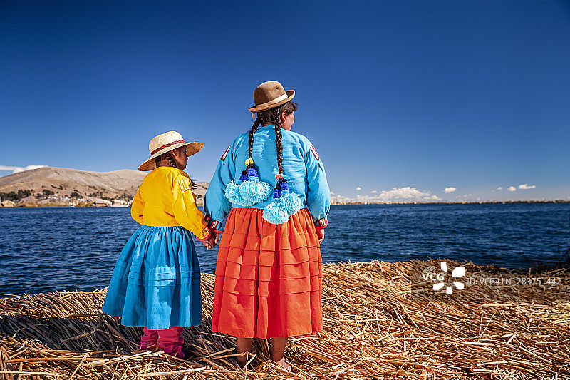 母亲和女儿在秘鲁的的喀喀湖的的喀喀湖乌罗漂浮岛上看风景图片素材