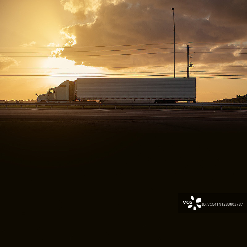 迈阿密乡村公路日落时分的半挂卡车图片素材