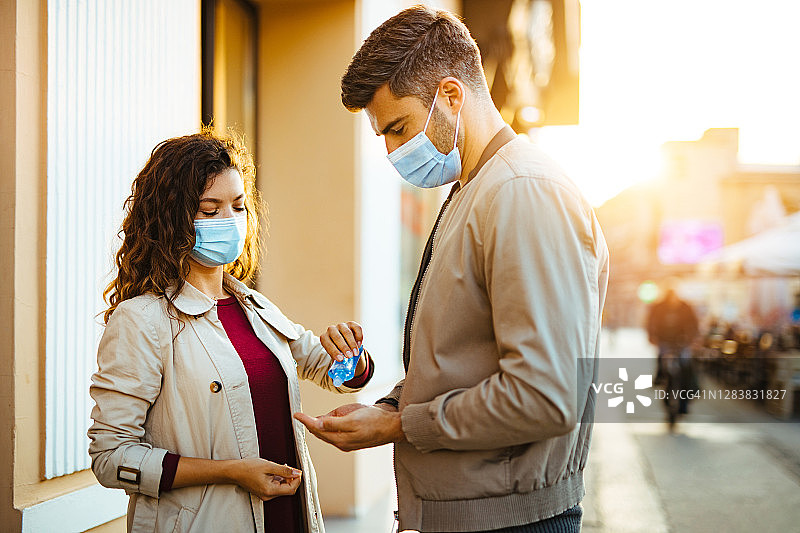 负责任的夫妇在冠状病毒大流行期间使用洗手液保护他们的健康图片素材