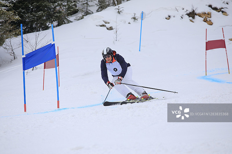 业余冬季运动：高山滑雪大回转比赛，滑雪者在滑雪胜地滑雪图片素材