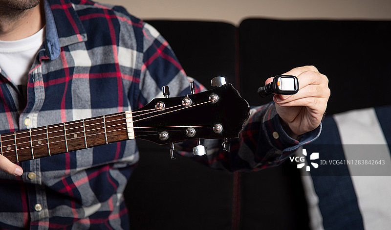 在家调音原声吉他的男人图片素材