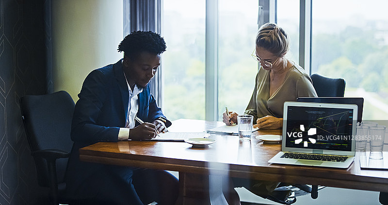 团队会议：女商人与非洲裔合作伙伴在会议室工作图片素材