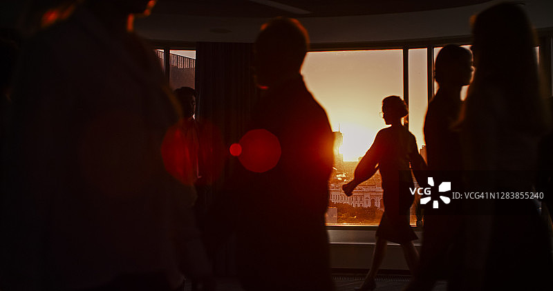 摩天大楼窗户与日落背景下的轮廓，股市分析会议图片素材