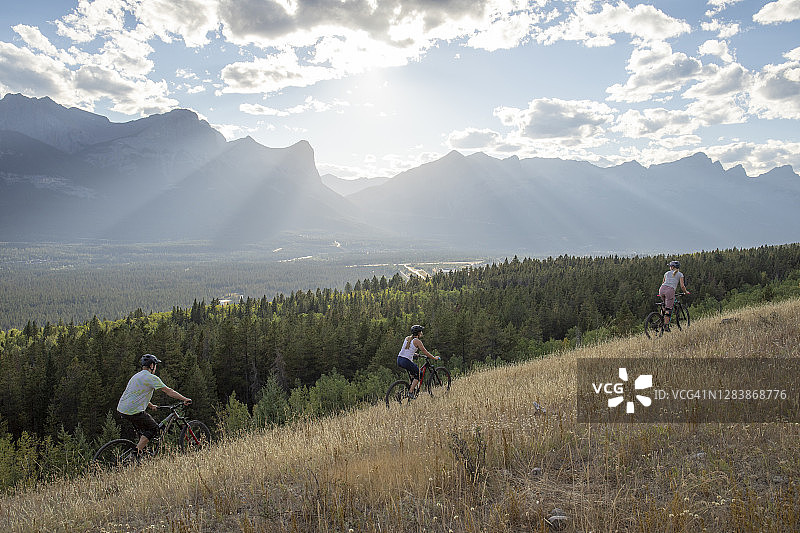 山地自行车手在清晨沿山脊骑行图片素材