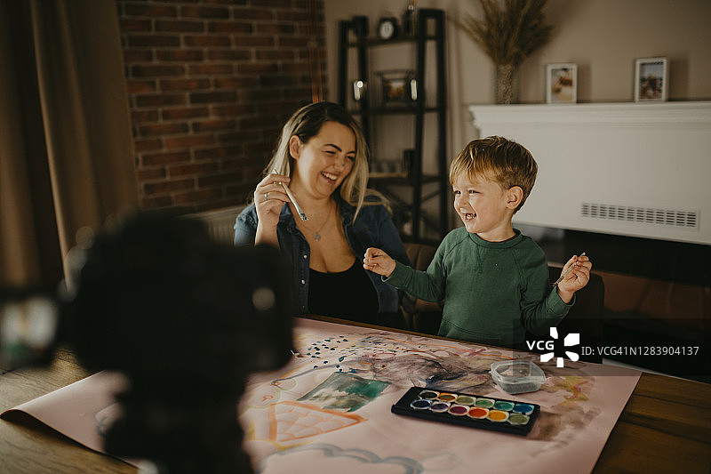 母亲和儿子一起绘画，并录制VLOG图片素材