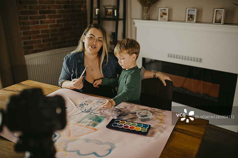 母亲和儿子一起绘画，并录制VLOG图片素材