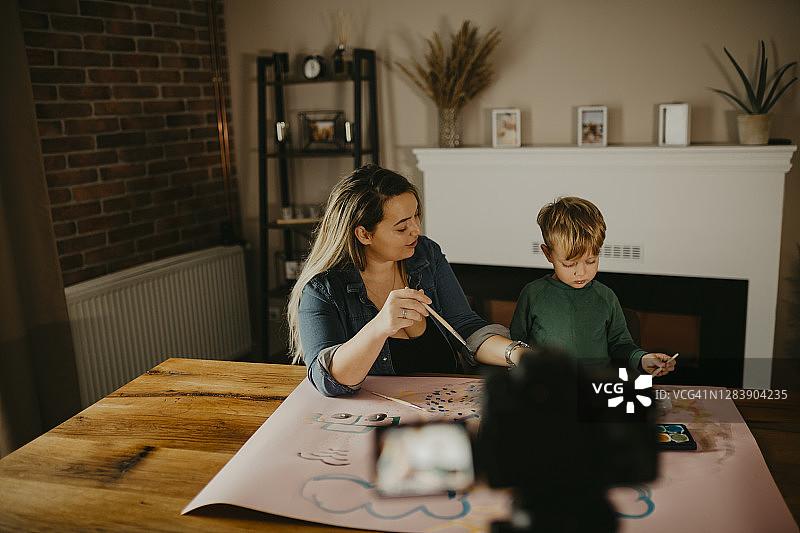 母亲和儿子一起绘画，并录制VLOG图片素材