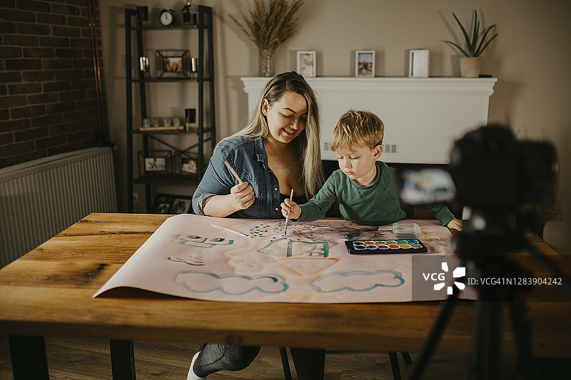 母亲和儿子一起绘画，并录制VLOG图片素材