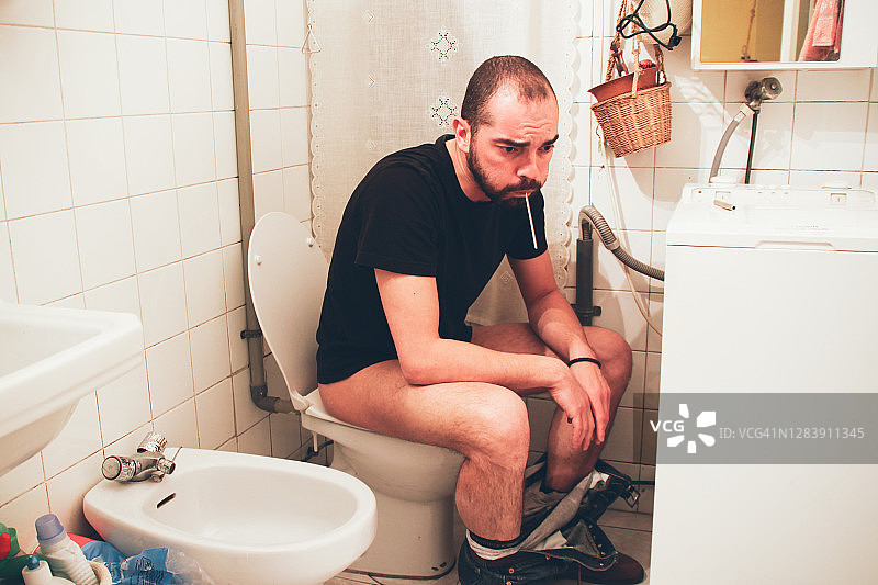 生病的男人在卫生间里图片素材