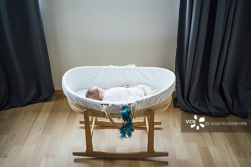 男婴躺在家里的婴儿床里图片素材
