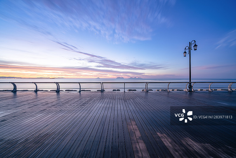 黎明时分的海边木板路图片素材
