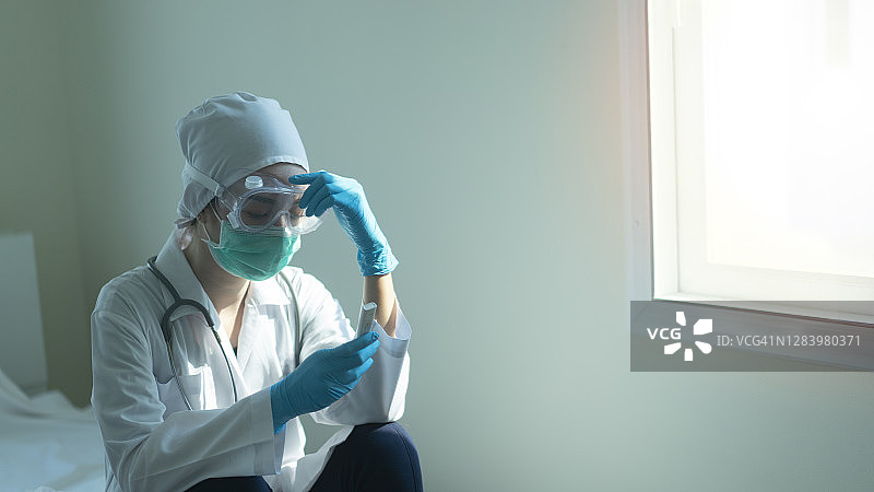 戴防护面罩和PPE套装的亚洲女医生，抗击新冠病毒疫情图片素材