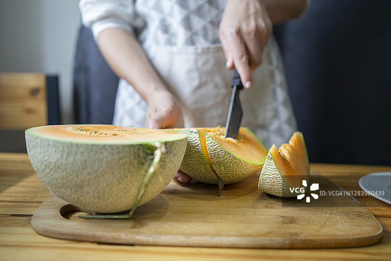 在木桌上切日本甜瓜，带文案空间图片素材