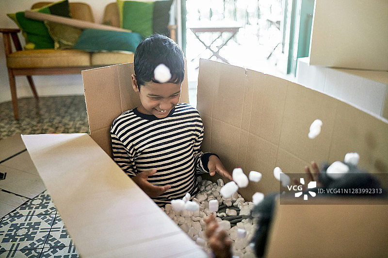 兄弟姐妹在纸箱里玩包装花生图片素材