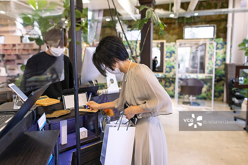 日本女人在美发沙龙的收银台付款图片素材
