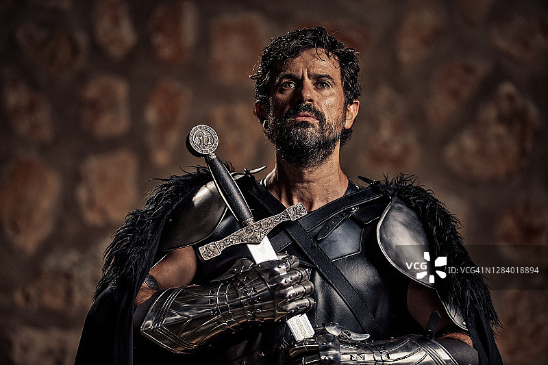 虔诚的中年奇幻中世纪骑士祈祷时手持剑图片素材