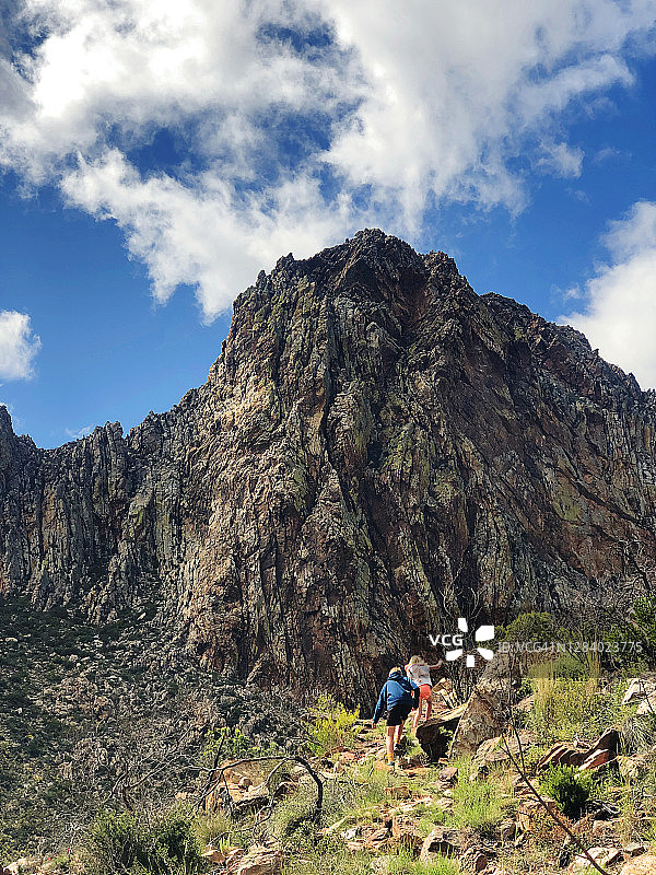 两个孩子徒步走向美丽的山岩峭壁图片素材