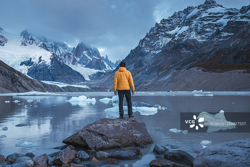 男子沉思冰川泻湖上的融冰图片素材