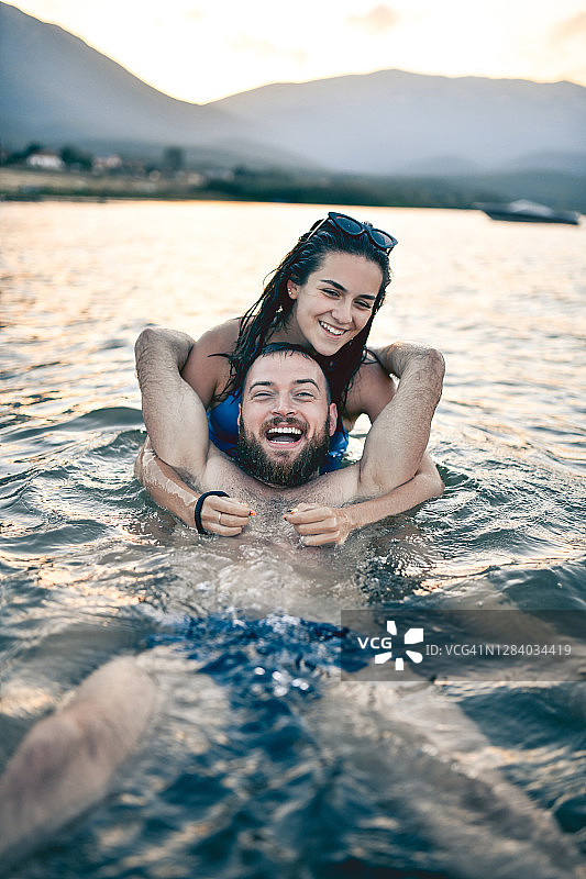 日落时在湖中一起游泳的夫妇图片素材