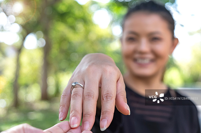 快乐的亚洲女人收到男友的订婚戒指图片素材