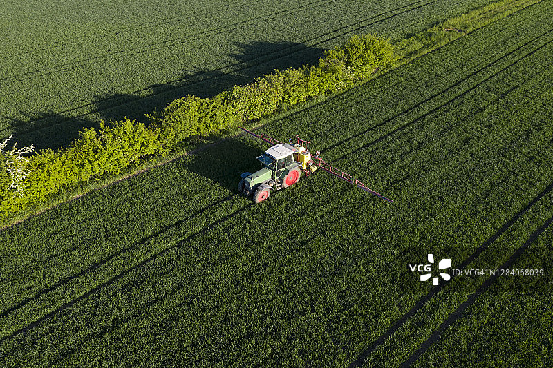 在麦田里作业的拖拉机，航拍视角图片素材