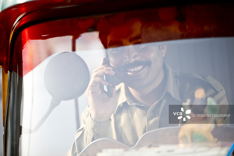 在人力车上讲手机的男人图片素材
