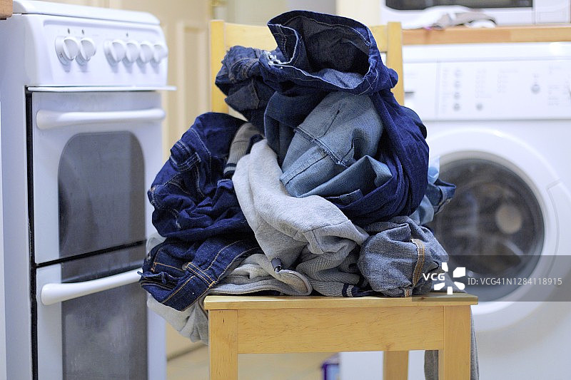 洗衣机旁的椅子上的衣物图片素材