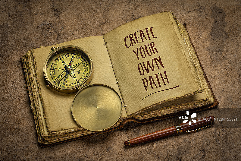 乡村木桌上的黄铜古董皮革日记本图片素材