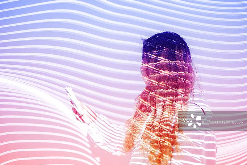 在全息背景下使用手机的女人图片素材