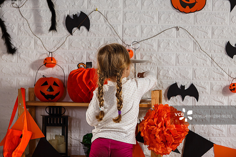 在房间里装饰万圣节的小女孩图片素材