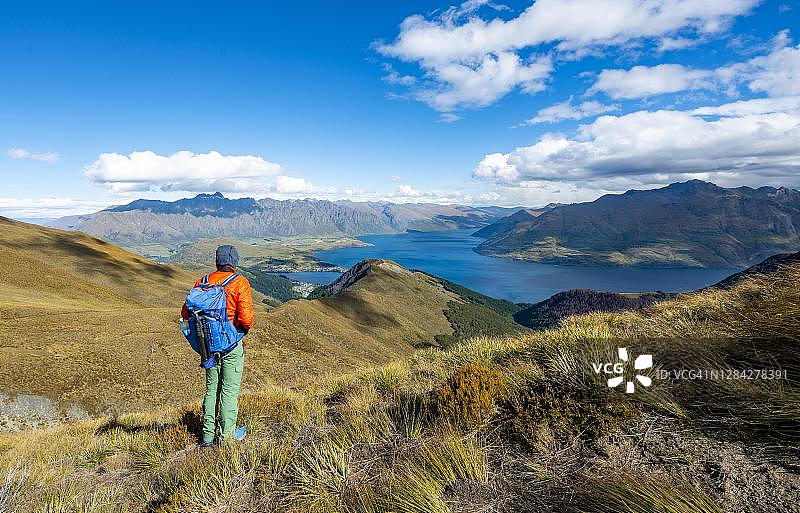 徒步者在本洛蒙德小径上，欣赏瓦卡蒂普湖和卓越山的美景，新西兰南岛奥塔哥南部阿尔卑斯山图片素材