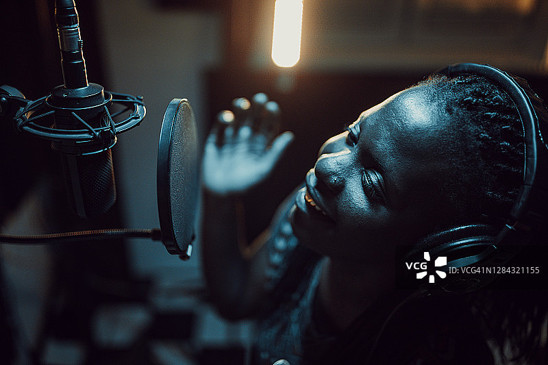 年轻的非裔美国女歌手在录音棚录制歌曲图片素材