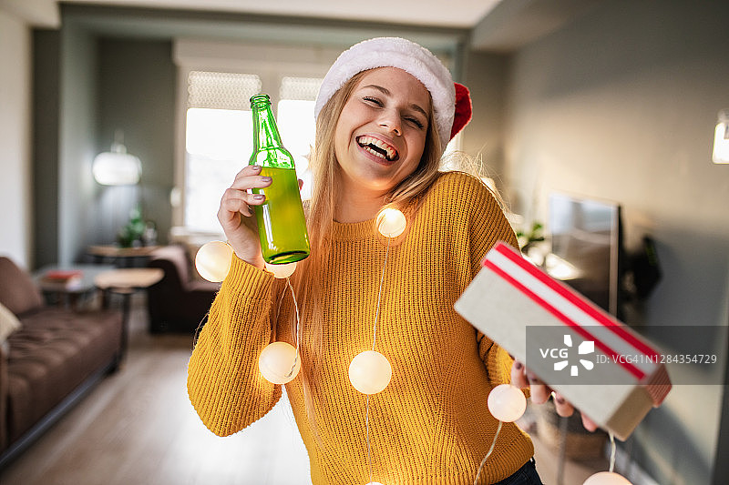 年轻女人在家拿着圣诞礼物的人物肖像图片素材