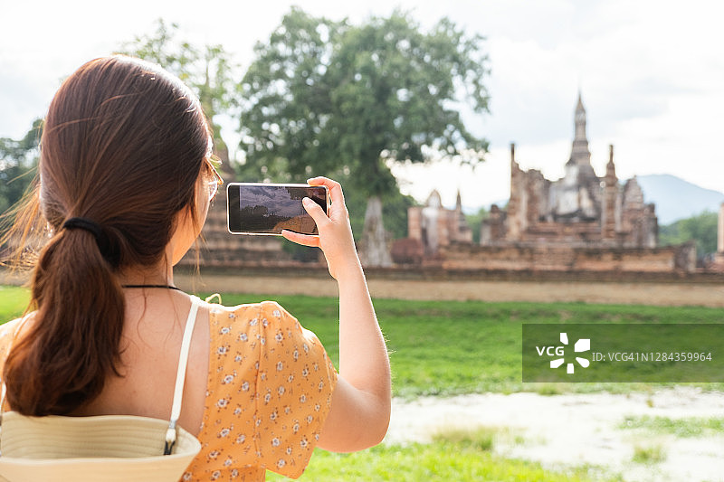 旅行者在泰国素可泰府玛哈泰寺拍摄佛像图片素材