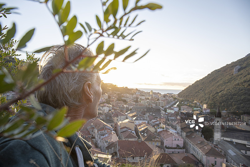 男人停下眺望海边村庄图片素材