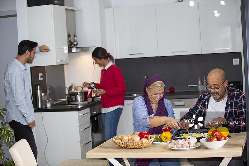 晚餐时在厨房里快乐的一家图片素材