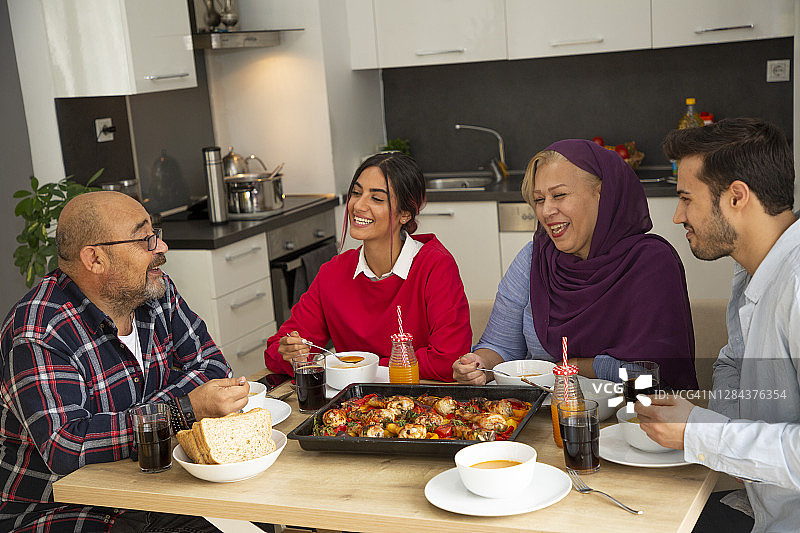晚餐时在厨房里快乐的一家图片素材