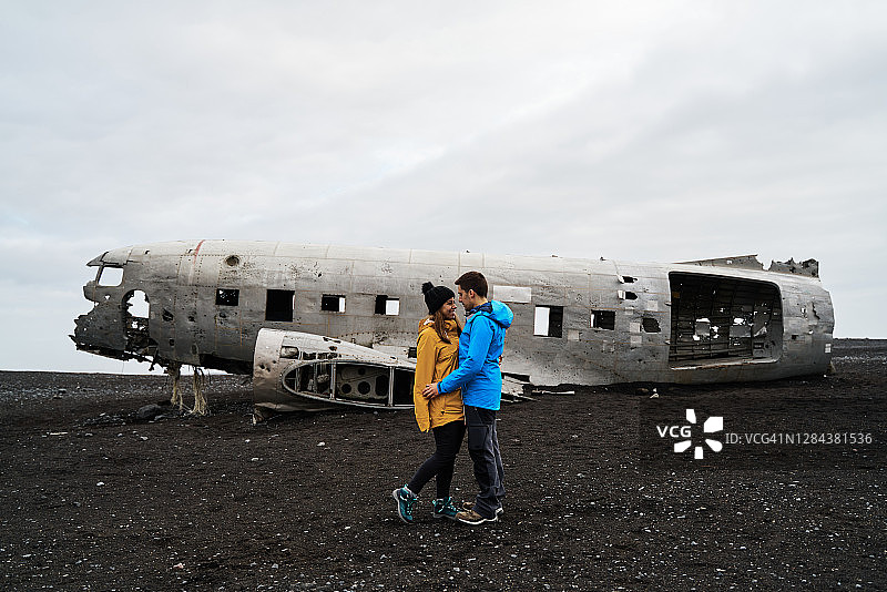 在损坏的飞机附近拥抱的幸福夫妇图片素材