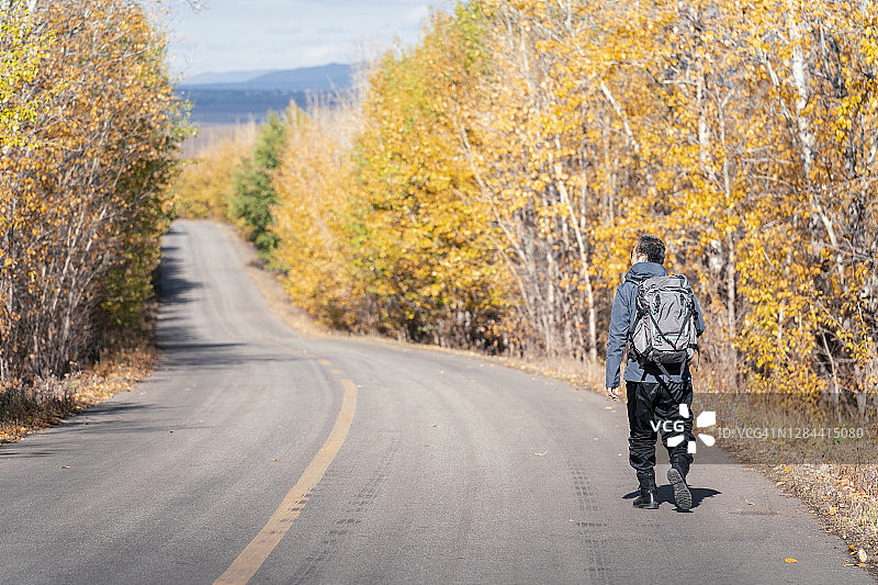 年长的男人在秋天的森林里徒步旅行图片素材