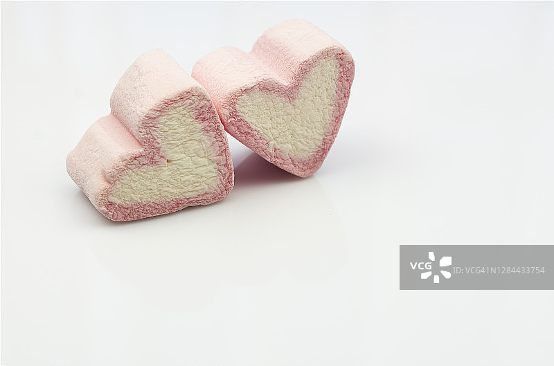 白色背景上的两个粉色心形棉花糖图片素材
