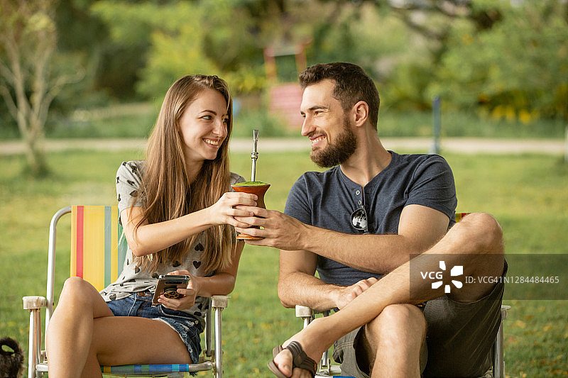 年轻情侣坐在公园里图片素材