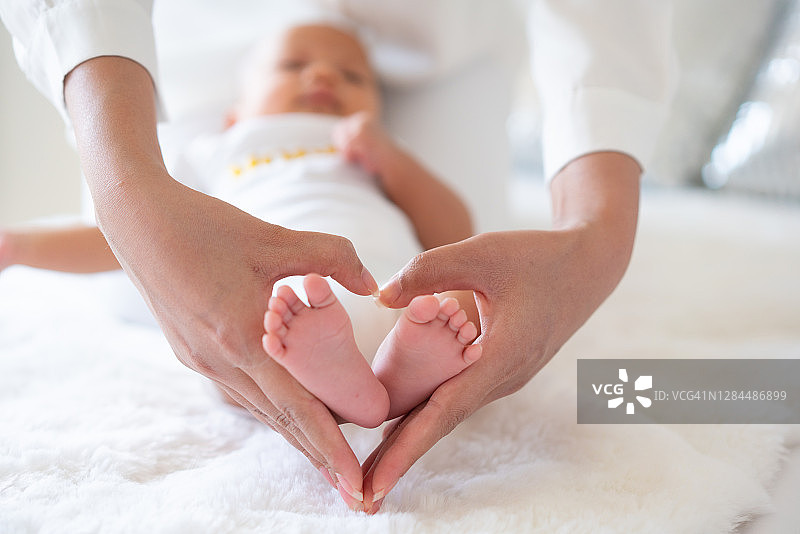 新生婴儿的小脚在父母手中，幸福家庭概念图片素材