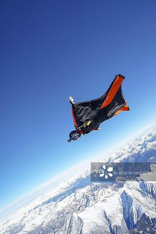 翼装飞行员翱翔于山地景观之上图片素材