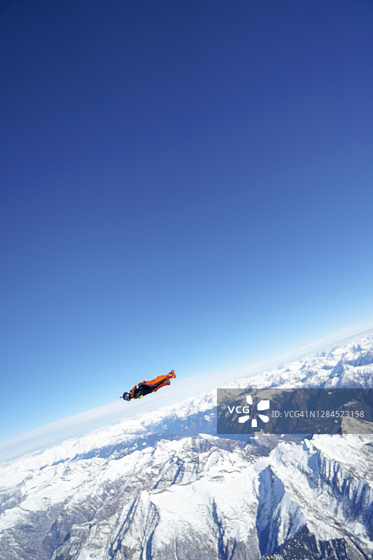 翼装飞行员翱翔于山地景观之上图片素材