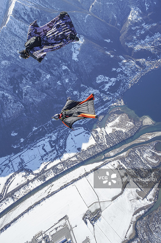 翼装飞行员翱翔于山地景观之上图片素材