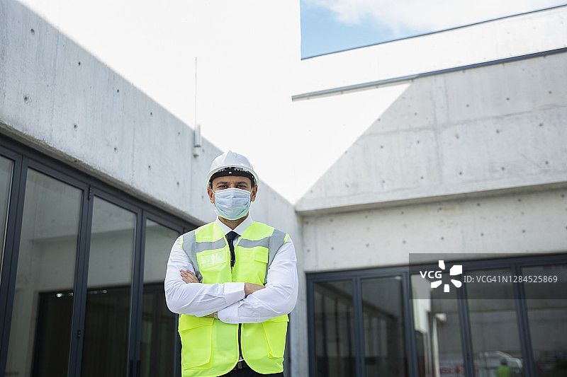 建筑工地戴卫生口罩的建筑工人肖像图片素材